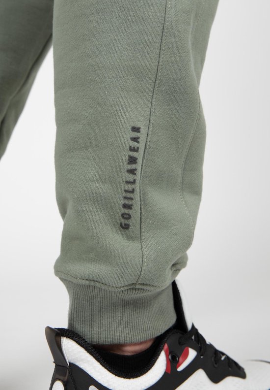Groene joggingbroek met zwarte 'GORILLAW EAR' tekst op het linkerbeen.