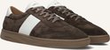 Bruine suède sneakers met witte strepen op de zijkanten, witte veters en bruine zolen.