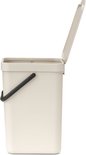 Licht beige prullenbak met open deksel en zwart handvat, op de zijkant gefotografeerd.