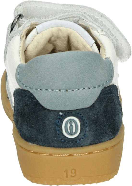 Achterkant van een witte sneaker met blauwe suède details, klittenband en de tekst '19'.