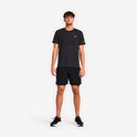 Man in donkergrijs gemêleerd T-shirt en zwarte sportbroek met ingebouwde compressieshort.
