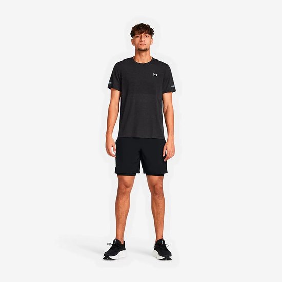 Man in donkergrijs gemêleerd T-shirt en zwarte sportbroek met ingebouwde compressieshort.