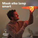 Man schroeft een lamp in een fitting. De lamp gloeit oranje. "Maak elke lamp smart. Behoud je bestaande lampen."