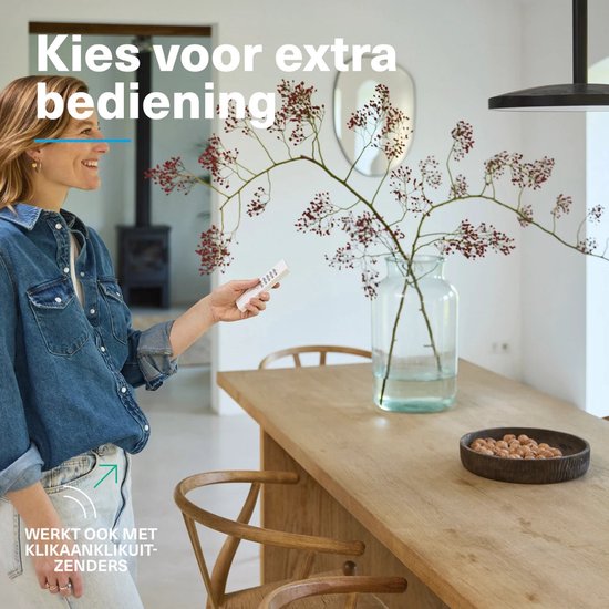 Vrouw met blonde haren, blauwe spijkerjas, houdt witte afstandsbediening vast. "Kies voor extra bediening."