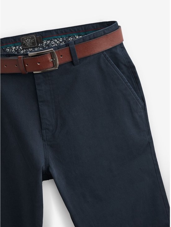 Bovenkant van een blauwe chino broek met bruine riem, tailleband met bloemenprint.