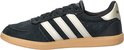 Zwarte Adidas sneaker met gouden strepen, gummi zool en perforaties.