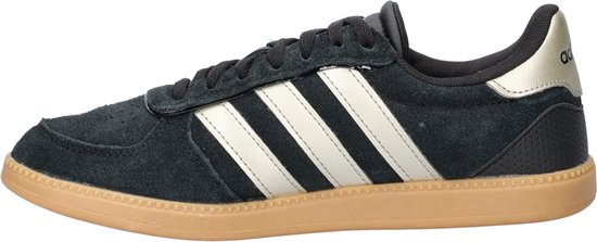 Zwarte Adidas sneaker met gouden strepen, gummi zool en perforaties.