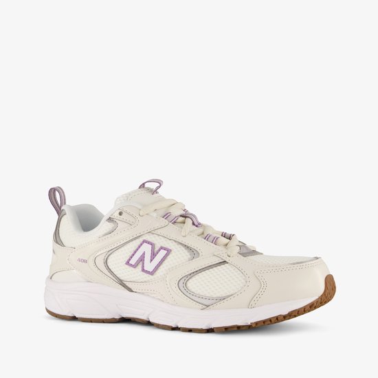 Crème New Balance 408 dames sneaker met paarse N-logo en zilveren accenten.