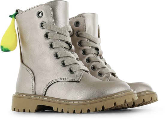Paar champagne metallic veterschoenen met een decoratieve banaan-hanger aan de zijkant.