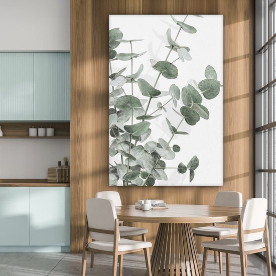 Canvas van eucalyptusbladeren in een eetkamer met een houten tafel.