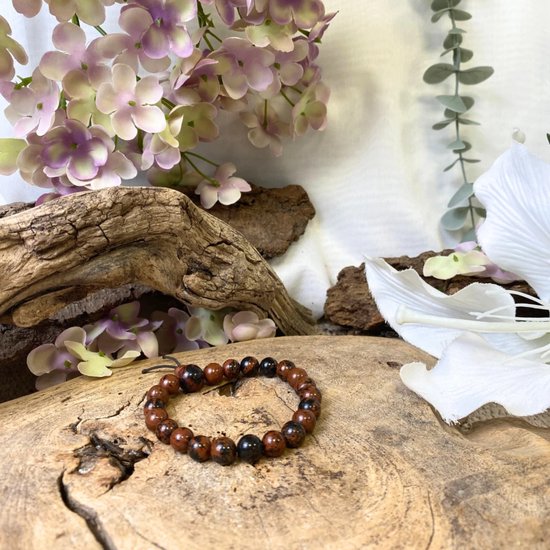 Mahonie obsidiaan kralen armband op een stuk hout, met bruine en zwarte tinten.