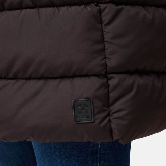 Detailopname van een zwarte patch met het X-TRAIL logo op de bruine gewatteerde jas.