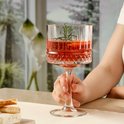 Hand die glas met rode drank, sinaasappel en rozemarijn vasthoudt.