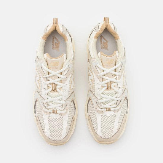 Bovenkant van beige New Balance 530 sneakers met witte veters.