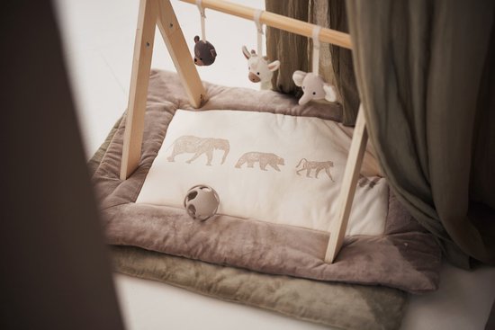 Houten babygym met beige speelmat met dierenprint, met hangende knuffels van een giraffe, beer en olifant.