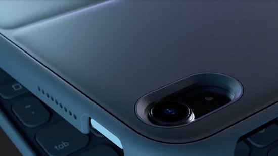 Gedetailleerde close-up van de donkergrijze achterkant van een tablet, met de cameralens en de zijkant van een toetsenbord.