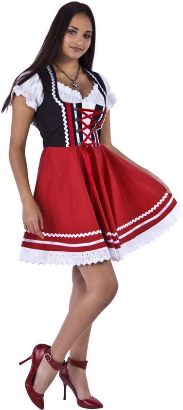Vrouw in rood met zwart dirndl-jurkje met witte off-shoulder mouwen, staand op rode hakken.