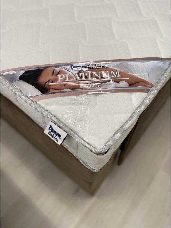 Topdekmatras met label "Platinum Bedding" en slapende vrouw.