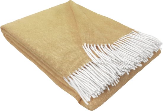 Okergele wollen deken met visgraatpatroon en witte franjes, geïsoleerd op een witte achtergrond.