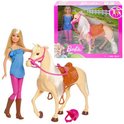 Barbiepop in blauw polkadot jurkje en roze legging naast beige paard met bruin zadel en roze hoofdstel.