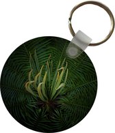 Sleutelhanger - Een bloeiende cycas plant op een zwarte achtergrond - Plastic - Rond - Uitdeelcadeautjes