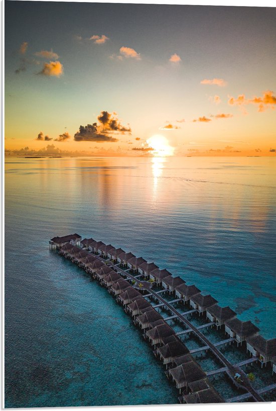 WallClassics - PVC Schuimplaat- Rij Vakantiehuisjes op het Water met Ondergaande Zon - 50x75 cm Foto op PVC Schuimplaat