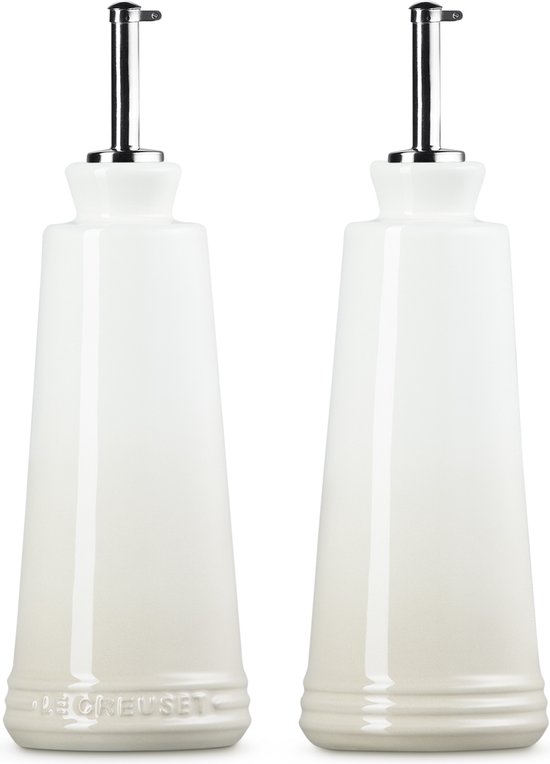 Twee Le Creuset Meringue kleurige oliekaraffen met chromen schenktuiten, voorzien van het Le Creuset logo.