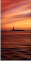 WallClassics - Poster Glanzend – Vrijheidsbeeld in New York van Ver met Zonsondergang - 50x100 cm Foto op Posterpapier met Glanzende Afwerking