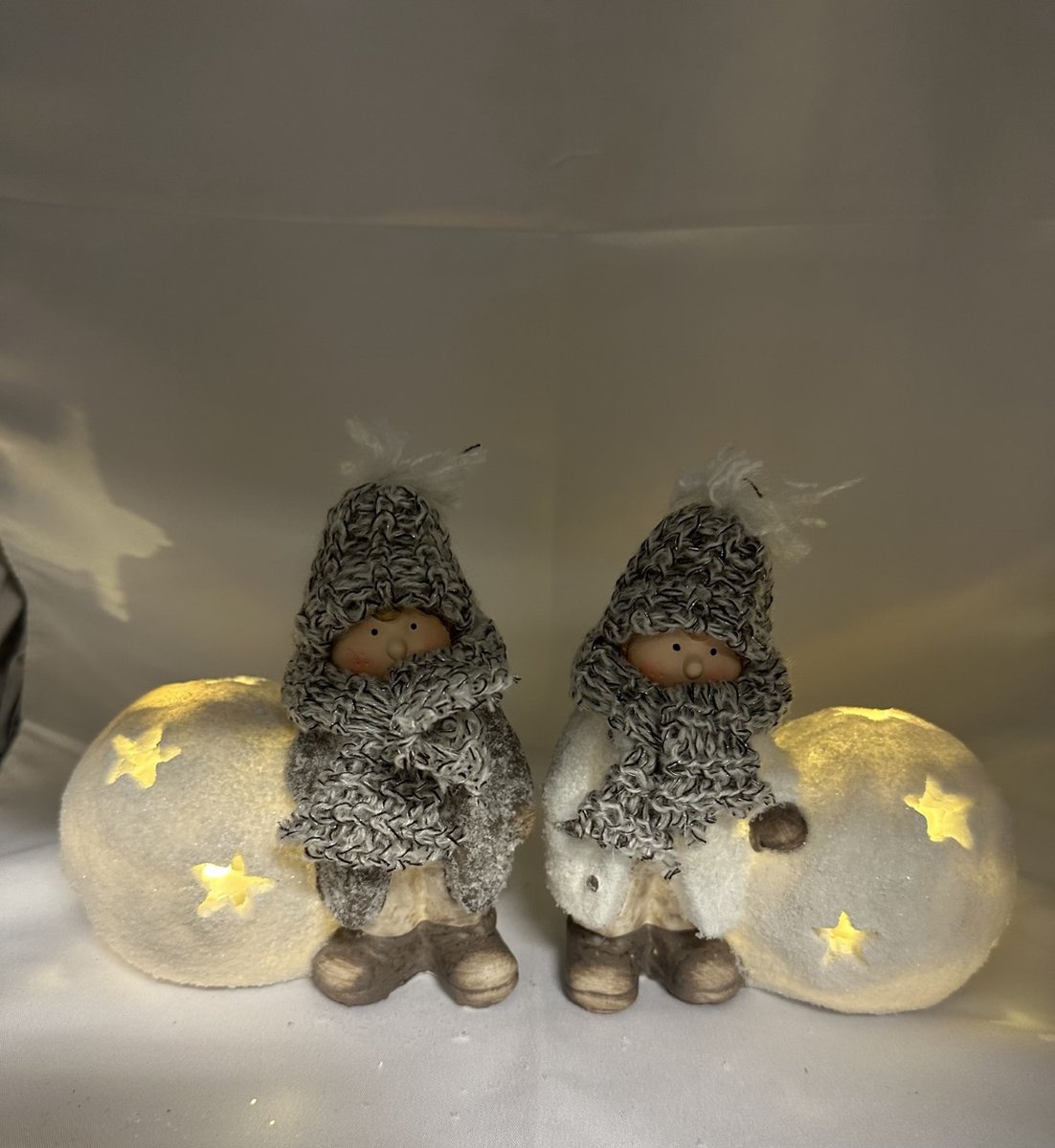Kerstbeeldjes kinderen met sneeuwbal + sterren en LED - Set van 2 stuks - taupe + wit + glitters & gebreide muts/sjaal - polyresin - 13 cm hoog x 15 cm x 11 cm – Kerstdecoratie