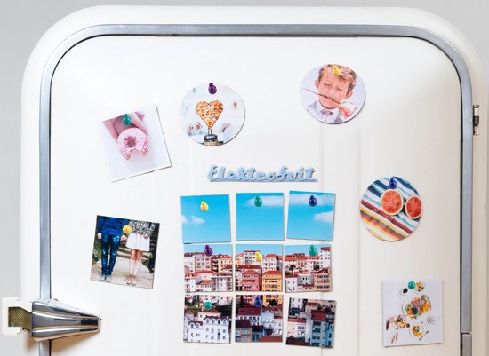 Witte koelkast met diverse foto's en magneten, waaronder een donut, wafel, stadsaanzicht en een jongen met strikje.