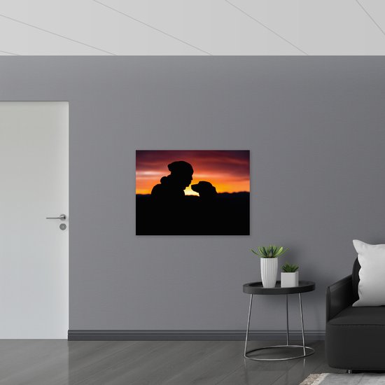 WallClassics - Poster Glanzend – Silhouet van Man met Muts met Zijn Hond - 100x75 cm Foto op Posterpapier met Glanzende Afwerking