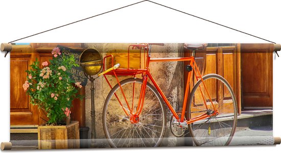 WallClassics - Textielposter - Oranje Fiets voor Café - 90x30 cm Foto op Textiel