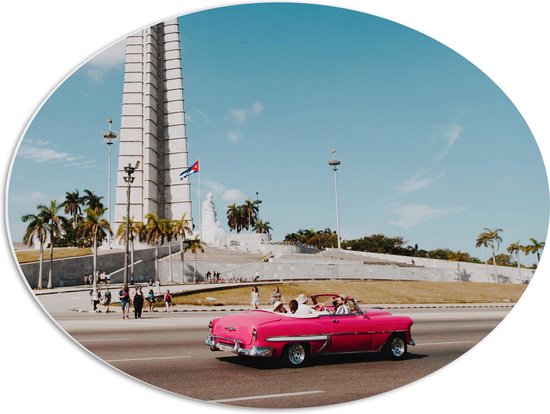 WallClassics - PVC Schuimplaat Ovaal - Roze Auto bij Gebouw in Cuba - 68x51 cm Foto op Ovaal (Met Ophangsysteem)