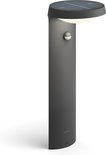 Antracietkleurige Philips sokkellamp met rond zonnepaneel en sensor.