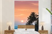 Behang - Fotobehang Zonsondergang op een eiland met de silhouetten van palmbomen - Breedte 145 cm x hoogte 220 cm