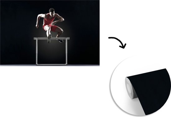 Athlète masculin saute par-dessus un obstacle de fotobehang