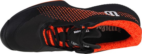 Dessus d'une chaussure de tennis noire avec doublure orange. Logo Wilson orange sur la semelle intérieure.