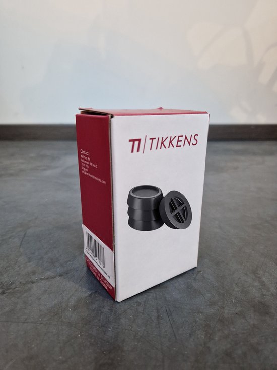 Doos met 'Tikkens' logo en vier zwarte trillingsdempers met kruispatroon.
