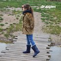 Meisje met luipaardprint jas en navy laarzen loopt over een houten bruggetje.