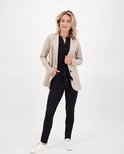 Model met zwarte broek met strikceintuur en beige gestreept jasje.