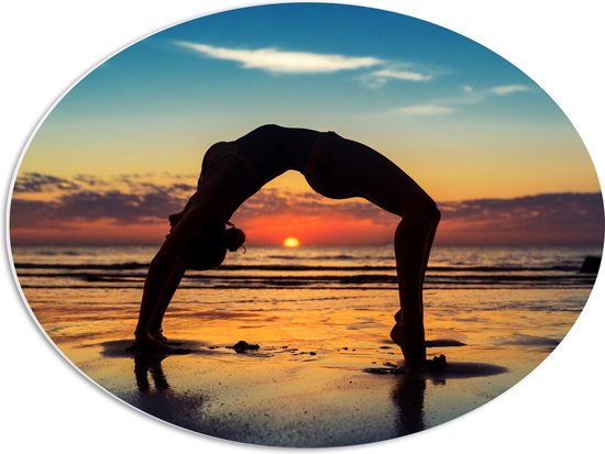 PVC Schuimplaat Ovaal - Vrouw in Yoga Positie op het Strand bij Ondergaande Zon - 56x42 cm Foto op Ovaal (Met Ophangsysteem)