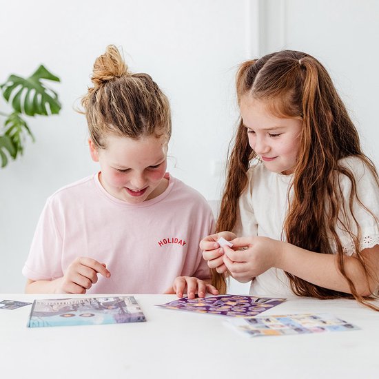 Deux filles assises à une table manipulent des autocollants.