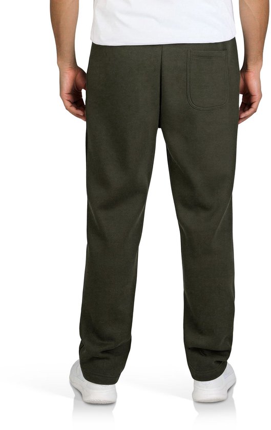 Achterkant van een olijfgroene joggingbroek met één achterzak op een model met witte sneakers.