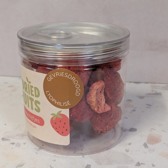 Transparante pot met gevriesdroogde aardbeischijfjes met label 'Gevriesdroogde aardbeischijfjes'.