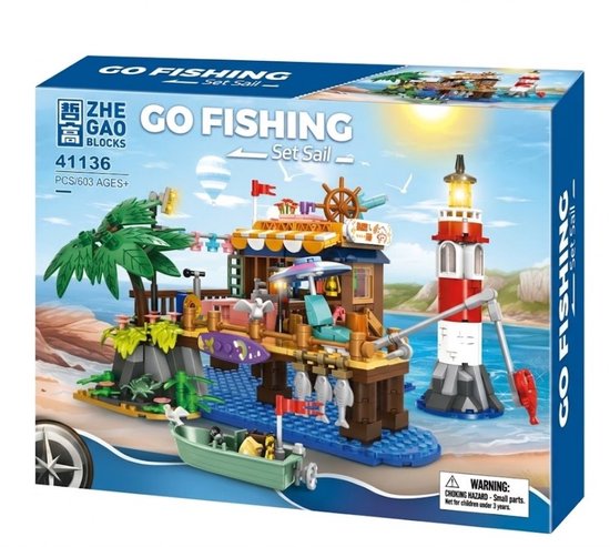 De doos van de vissershut met vuurtoren, boot, palmbomen en krab, met de tekst 'GO FISHING - Set Sail'.