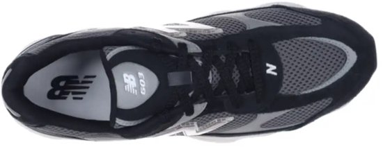 Topview van een zwarte New Balance sneaker met grijze mesh en suède, witte zool.