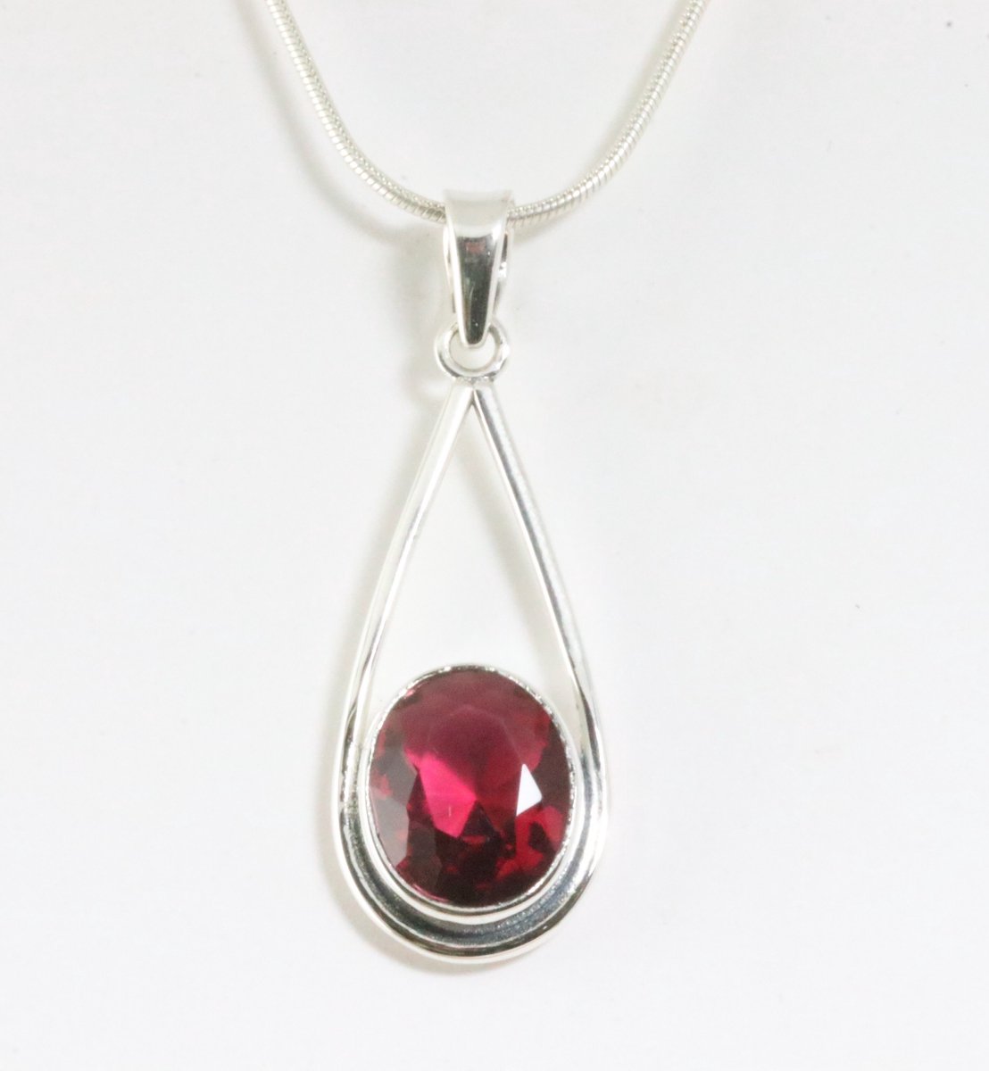Opengewerkte zilveren hanger met roze toermalijn aan ketting