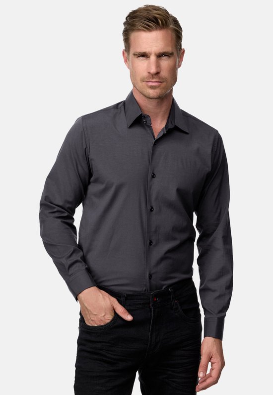 Model draagt een donkergrijs Rusty Neal overhemd met lange mouwen en zwarte jeans.