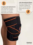 Zwarte kniebrace met oranje banden en ingebouwde spiraalveren voor zijdelingse ondersteuning.