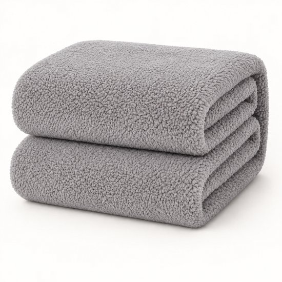 Deux couches pliées de tissu polaire teddy gris texturé sur un fond blanc.